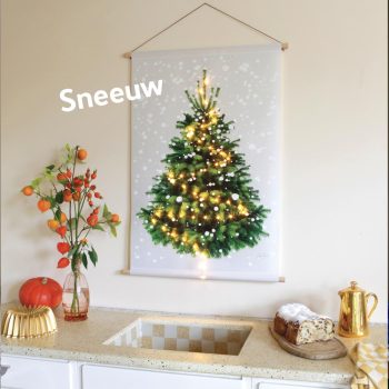 Er hangt een kerstboom-op-doek op een keukenmuur. Het is zo'n mooie ouderwetse keuken, met een granito aanrechtblad. Rechts een kerstbrood en een gouden theepot. Links een pompoen en een gouden taartvorm.