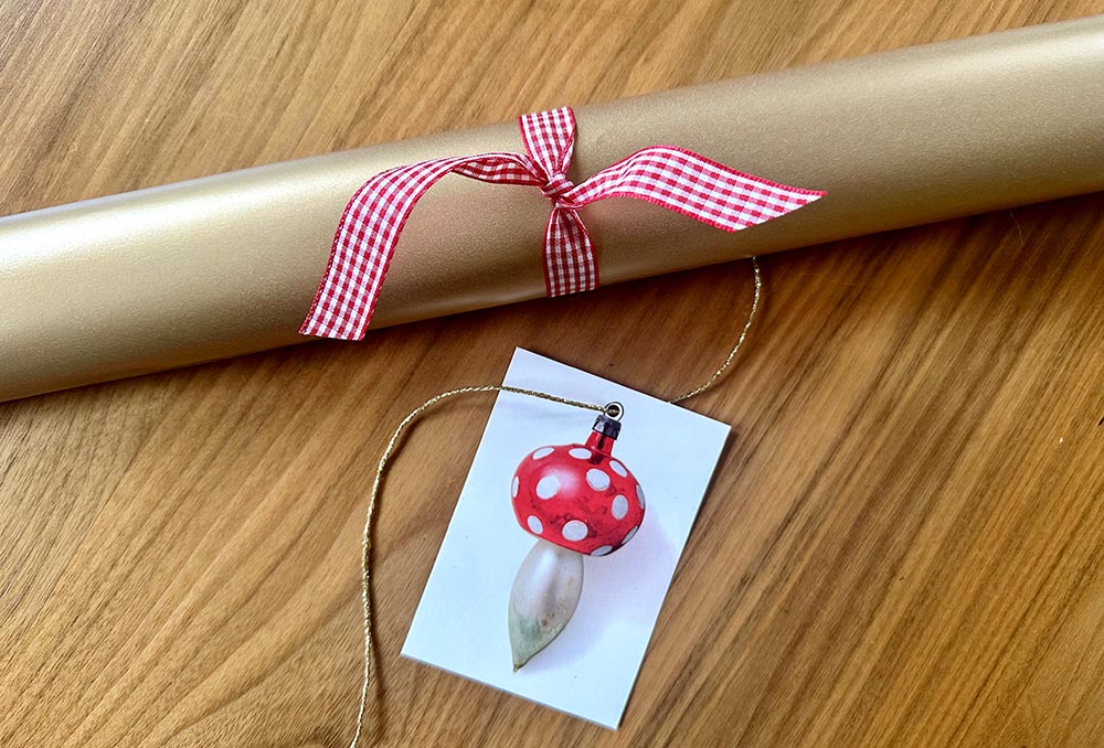 duurzaam relatiegeschenk cadeauverpakking lr Een kerstcadeau met rood strikje en een kaartje met daarop een kerstbal-paddestoel. Feestelijk!
