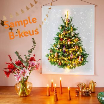 Kerstboomwandkleed (gezellig met kerstballen en kerstlichtjes) hangt boven een tafel met kerstbloemen en kaarsen. Heel sfeervol.