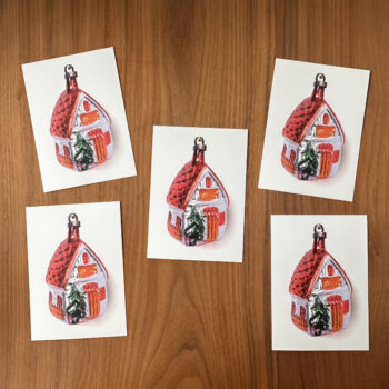 5 kerstkaarten op tafel. (met afbeelding van kerstbal in vorm van huisje)